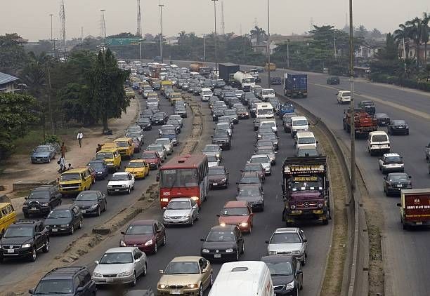 Heavy traffic congestion on a multi-lane highway with cars and buses during daytime.